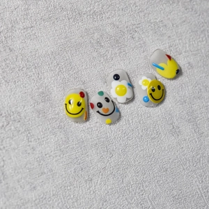 Détail de stickers à ongles en relief mat avec visages souriants et motifs floraux colorés