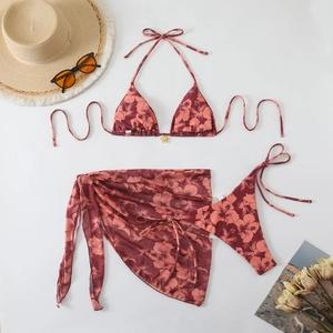 Flat lay detail of tropical hibiscus print bikini set with matching mesh sarong wrap