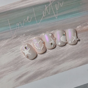 Detail of seashell pearl nail art stickers with starfish and mermaid charms