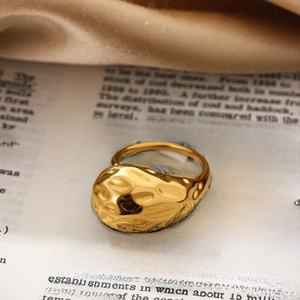 Detailed close-up of a chunky 18K gold textured ring with organic molten lava pattern