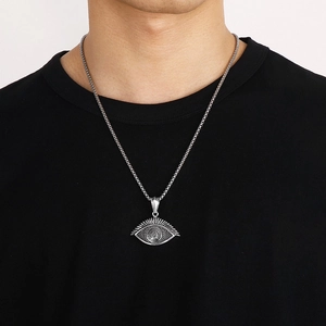 Vintage silver sea turtle pendant necklace with evil eye design on black t-shirt