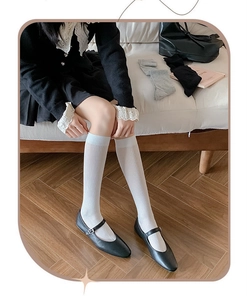 Close-up of white, grey, and black ribbed knee-high socks with detailed knit texture