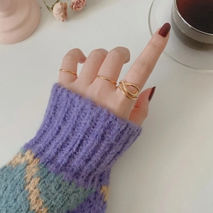 Three-piece gold ring set featuring minimalist bands and unique overlapping crisscross design