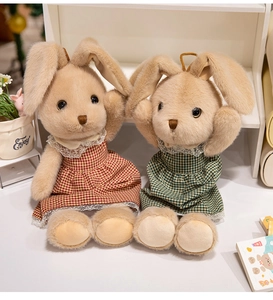 Dettaglio di coniglietti di peluche con abiti a scacchi rossi e verdi e pizzo