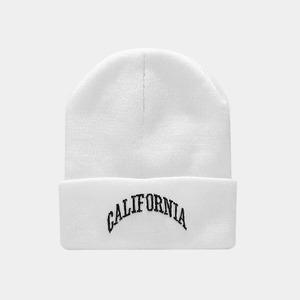 Close-up of white knit beanie featuring black California embroidery on the folded cuff