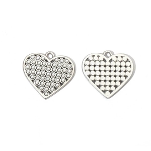 Macro view showing both sides of silver heart wing charms with dimpled texture