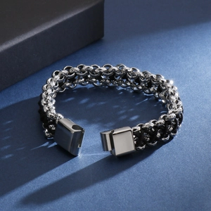 Vue rapprochée du fermoir magnétique carré sur un bracelet tressé en acier et cuir