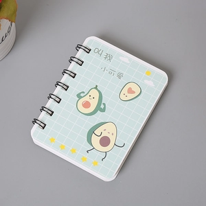 Detail of A7 spiral notebook featuring a cute cartoon avocado on a light blue grid cover