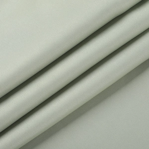 Détail du tissu satiné vert sauge montrant la texture lisse et le drapé élégant de la robe