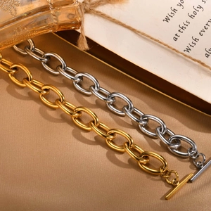 Detailed macro shot of gold and silver chunky chain bracelets with OT toggle clasps
