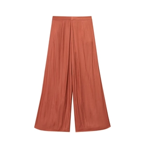 Damesbroek met wijde pijpen van gebrand oranje satijn met een zijdezachte en glanzende look
