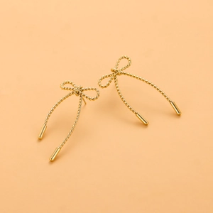 Détail de boucles d'oreilles nœud plaquées or 18 carats avec texture de corde torsadée