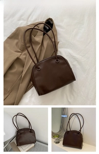 Detail view of the dark brown leather moon bag with golden zipper and slender shoulder strap