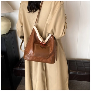 Detail of vintage brown faux leather shoulder bag with white faux fur trim and horn button