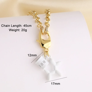 Gros plan d'une chaîne plaquée or 18k avec pendentifs tasse à café et chien ballon blanc