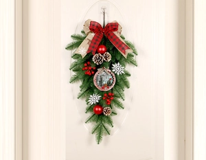 Gros plan de dcoration de Noël avec plaque Holly, pommes de pin et nœud à carreaux