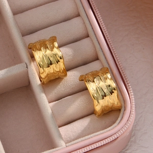 Dettaglio degli orecchini a C larghi placcati oro 18K con finitura martellata unica