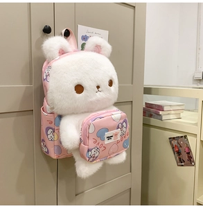 Close-up of pink rabbit plush backpack with soft long fur and heart pattern prints
