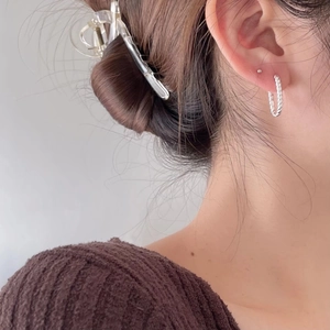 Elegant 925 sterling silver twisted hoop earrings with a textured rope design on female model