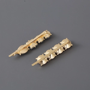 Detailed back view of two gold metal hair clips showing secure clip structure and clasp