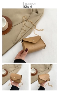 Detailed close-up of khaki mini crossbody bag with crocodile pattern and gold chain strap