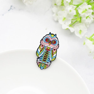 Macro detail of colorful enamel owl brooch with artistic floral and marble background
