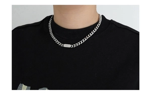 Detailed close-up of a silver titanium steel Cuban link chain with a rectangular tag
