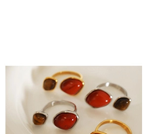 Macro shot of retro gold and silver rings with irregular red and brown stones