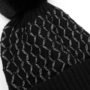 Detailed close-up of black ribbed knit beanie with silver embroidery and faux fur pompom