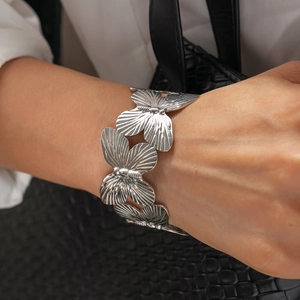 Macro detail of silver butterfly cuff bracelet featuring intricate openwork wing patterns