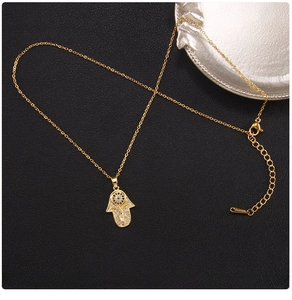 Detail of gold Hamsa Hand necklace with evil eye design and polished titanium steel chain
