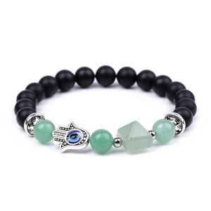 Detailed view of beaded bracelet with green pyramid and Hamsa Hand evil eye charm