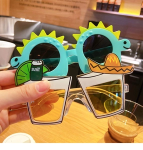 Detail of funny party sunglasses with blue dinosaur and cocktail glass frame held by hand