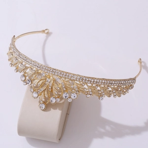 Close-up of golden bridal crown featuring intricate hollow design and clear rhinestones