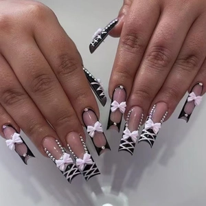 Long French press-on nails with 3D white bows, rhinestones and crisscross patterns