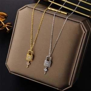 Luxe crystal-encrusted key and lock necklaces in gold and silver finish on a leather box