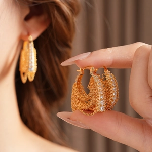 Detail of gold-plated chain earrings featuring sparkling zircon pave in a geometric style