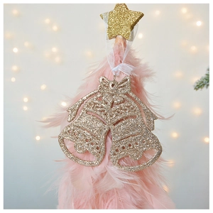 Close-up of sparkling champagne gold bells with hollow design and white silk ribbon