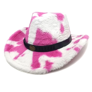 Detalle de sombrero vaquero de felpa con estampado de vaca rosa y emblema de bronce