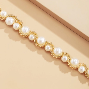 Close-up of woven white pearls with spiral gold wire craft on a tiered layered necklace