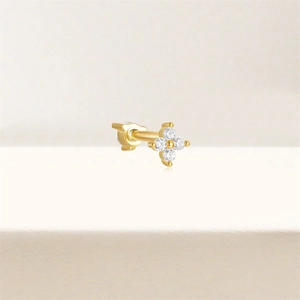 Detail of gold floral cartilage stud earring with four marquise-cut clear crystals