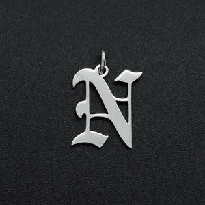 Close-up of a silver Gothic letter N pendant crafted from polished stainless steel