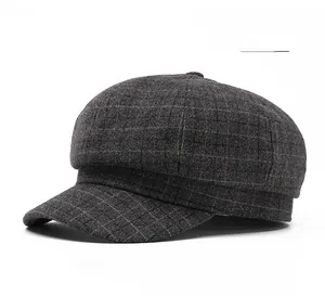 Detail of dark grey plaid newsboy cap showing thick wool texture and classic pattern