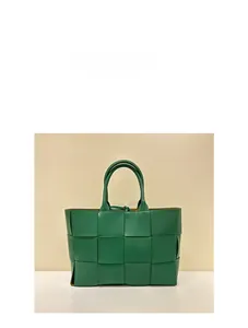 Detail of green hand-woven leather tote with square weave design and inner zipper pouch