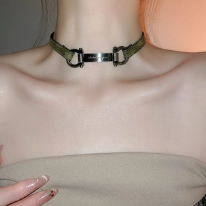 Close-up of vintage dark green leather choker with metal Gancini logo buckle on neck