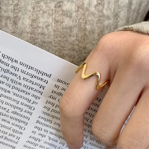 Minimalist wavy 18K gold plated ring for women styled with casual knitwear and book