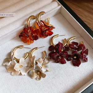 Detailed view of resin flower petal hoop earrings in amber, burgundy and marble grey