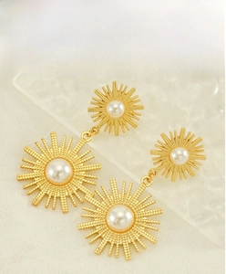 Gros plan de boucles d'oreilles tournesol vintage avec perles et plaquage en or 18K