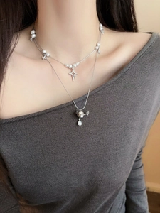 Close-up of double-layered pearl and Saturn pendant necklace with zircon droplet detail