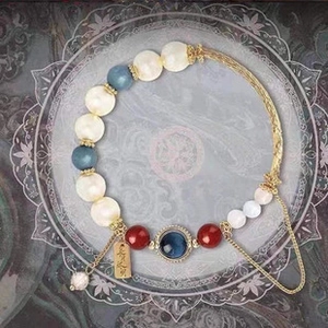 Detail of multi-color gemstone beads and golden tag engraved with Chinese characters
